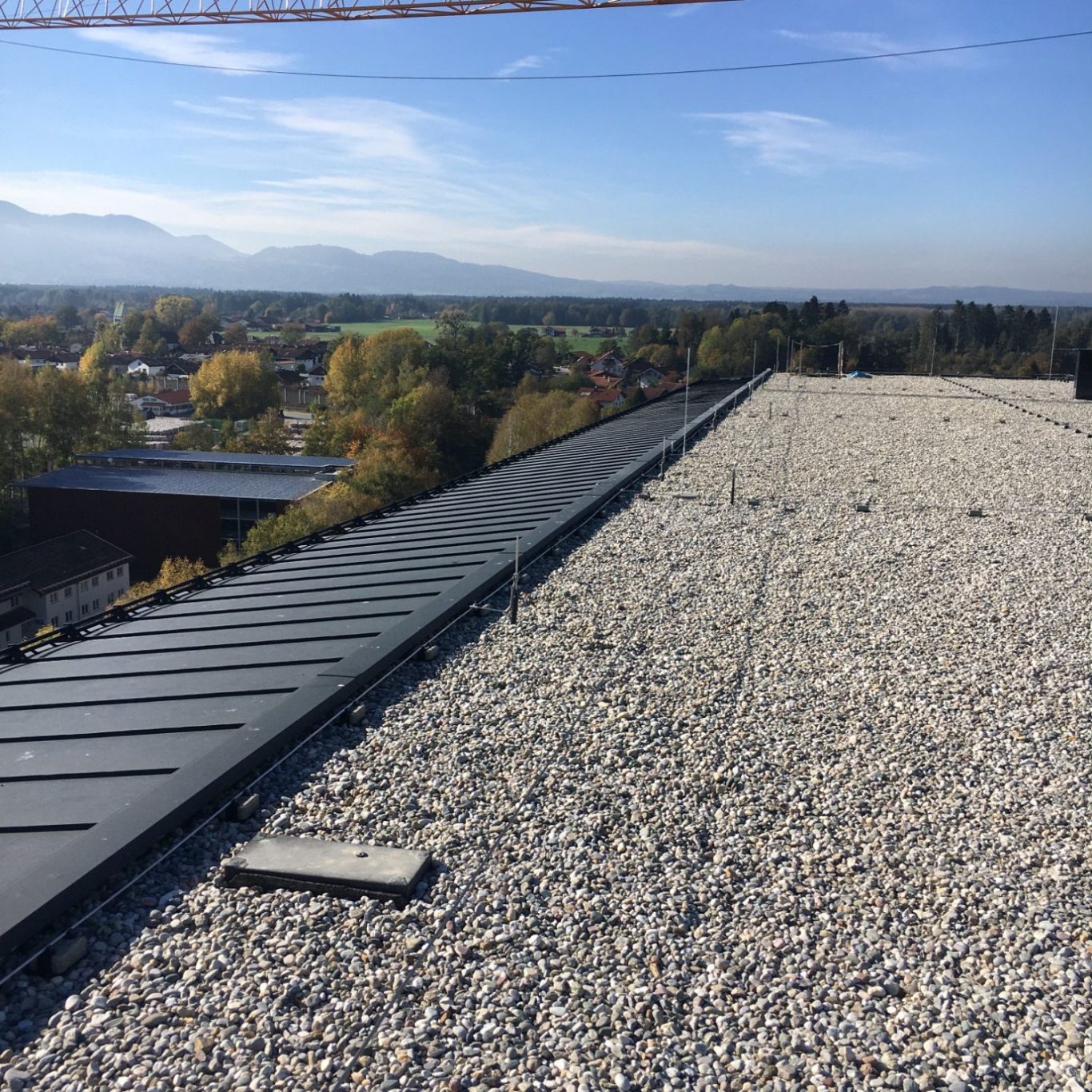 Kiesdach Inspektion Rosenheim Kiesdach mit Seilsicherungssystem und Alpenpanorama im Herbst